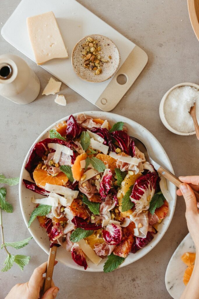 Raddichio citrus prosciutto salad on table 865x1297